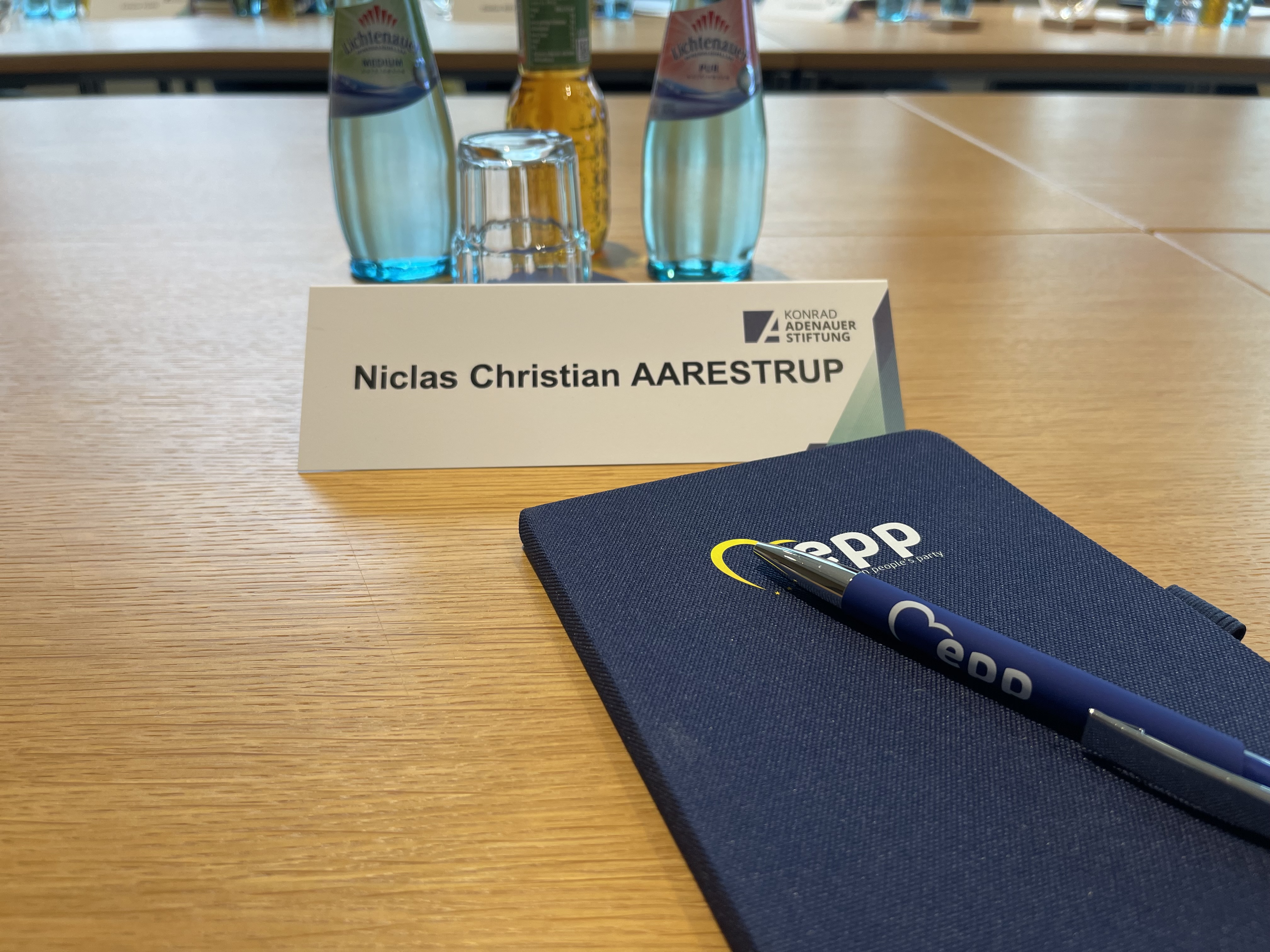 Konferencebord med navneskilt, notesbog og EPP-kuglepen til dialogmøde hos Konrad Adenauer Stiftung i Berlin